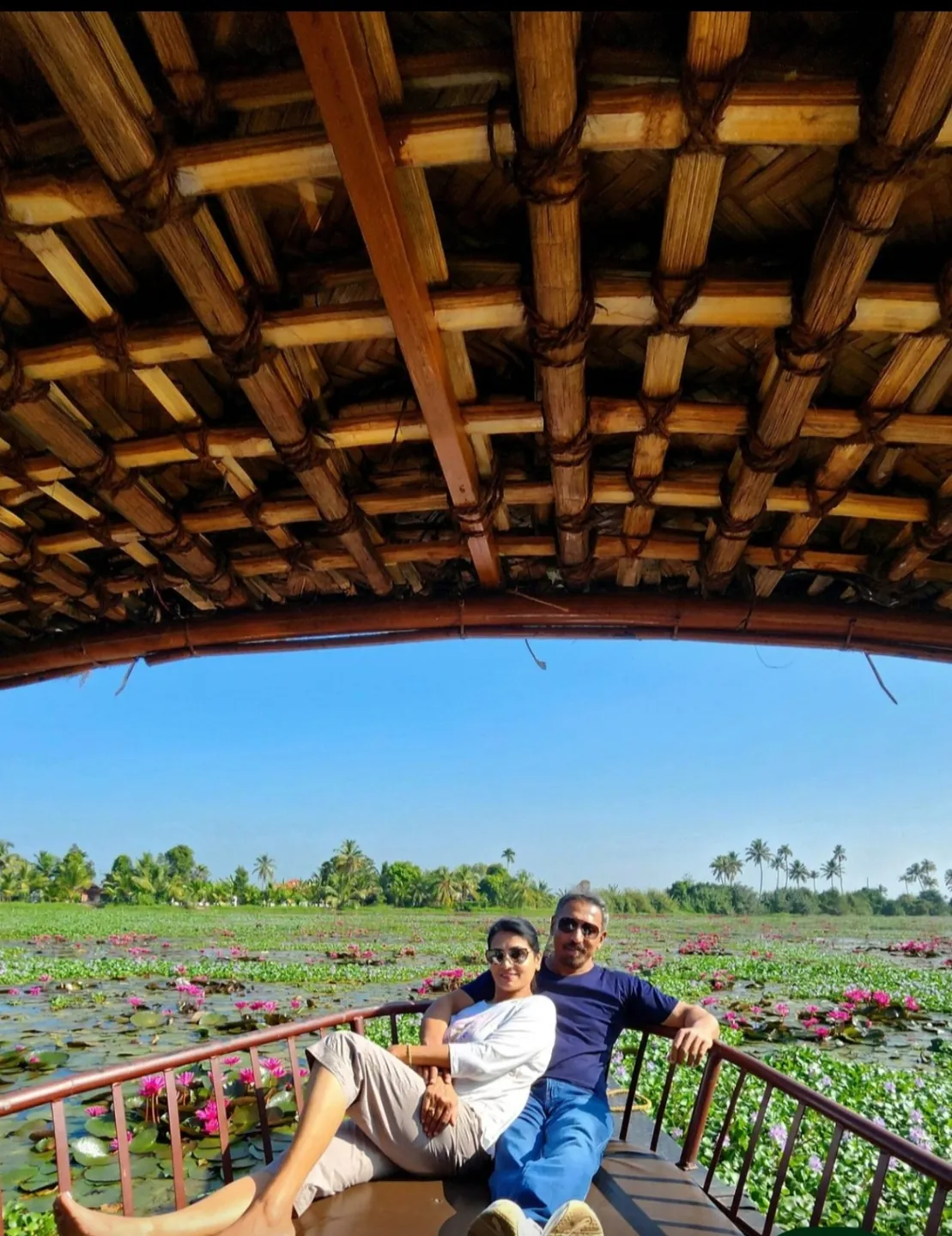 A couple relaxing on a covered boat among water lilies