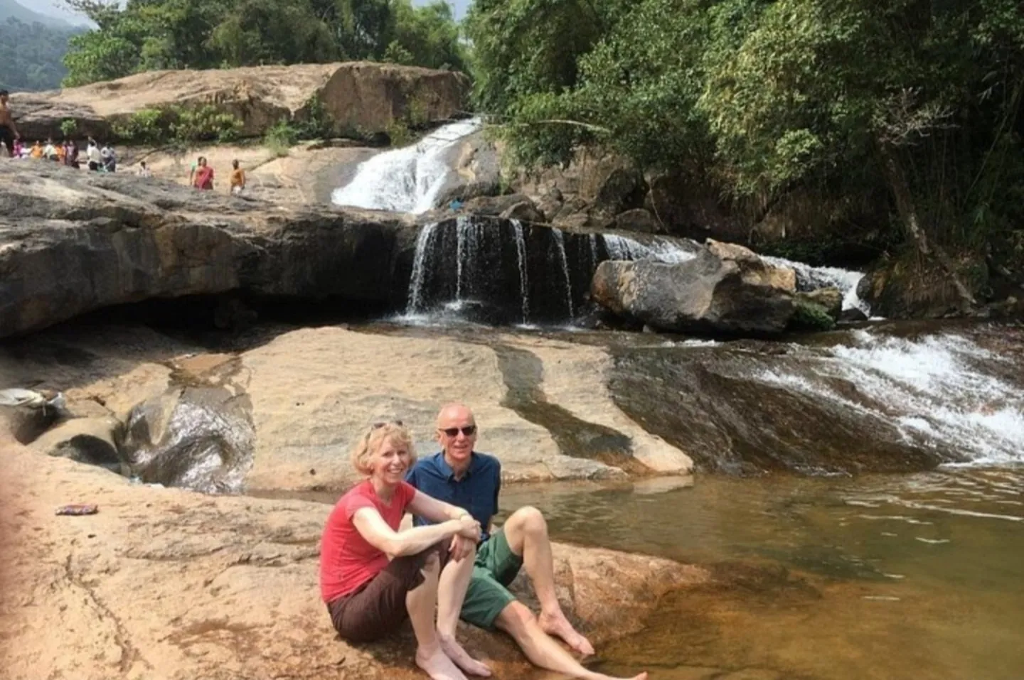 Travellers enjoying a waterfall stop in the Munnar region