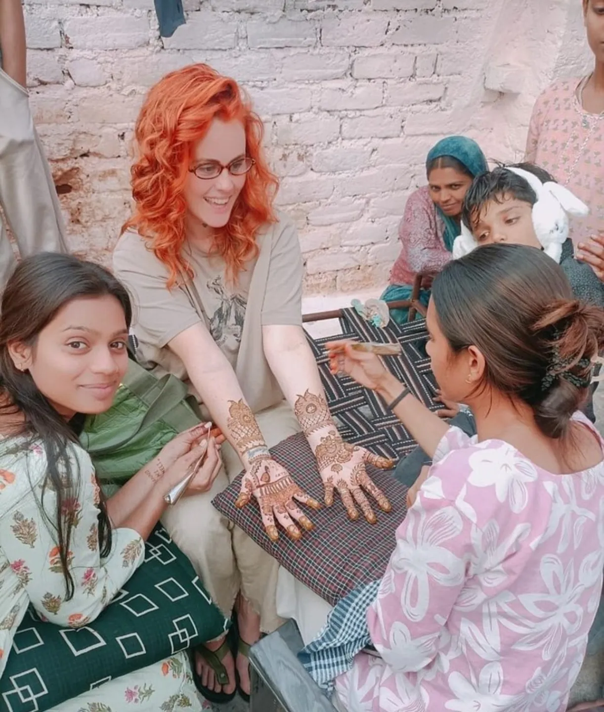 A visitor having mehndi applied during a local encounter