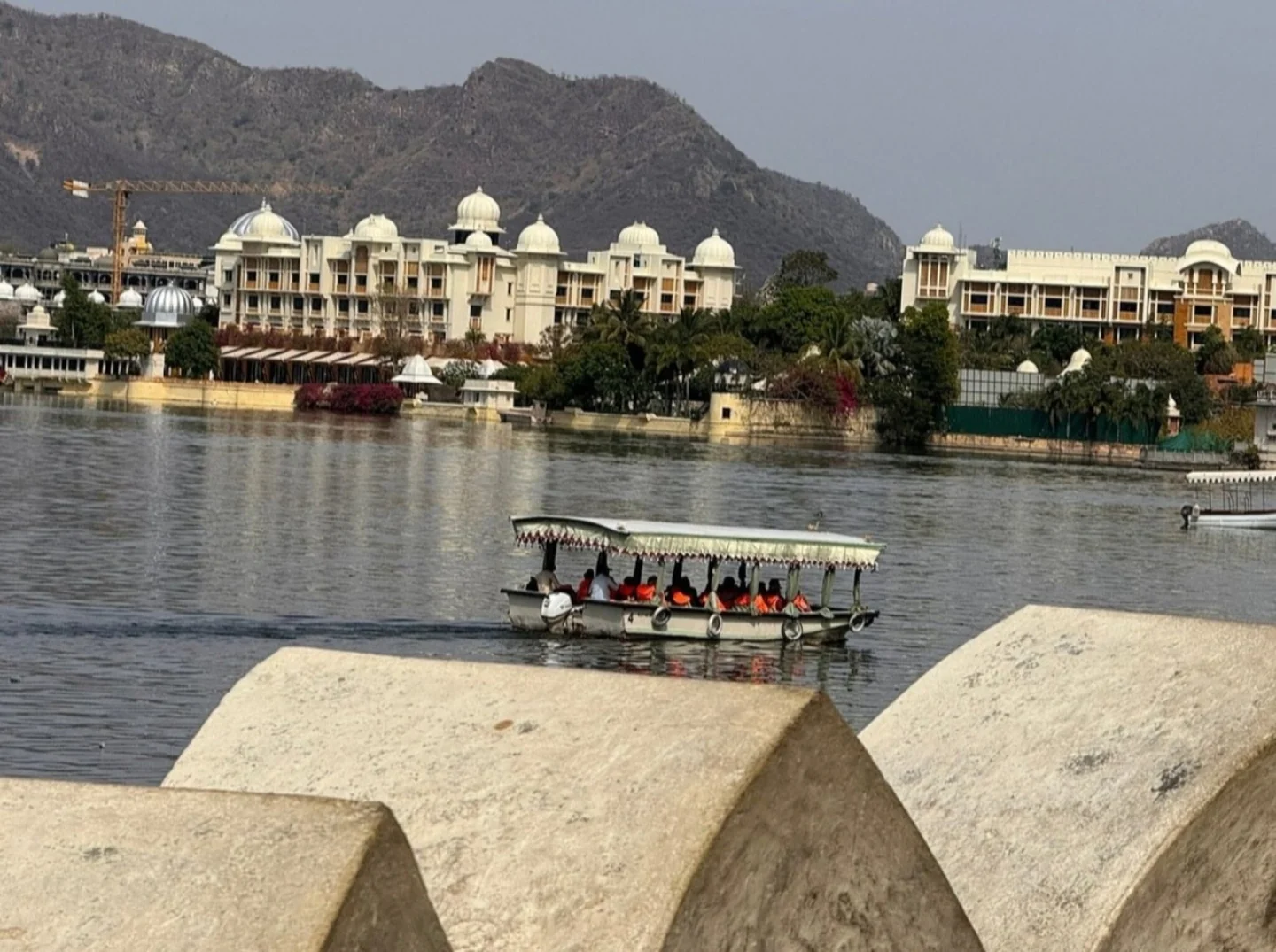 A boat passing lakeside buildings in Udaipur